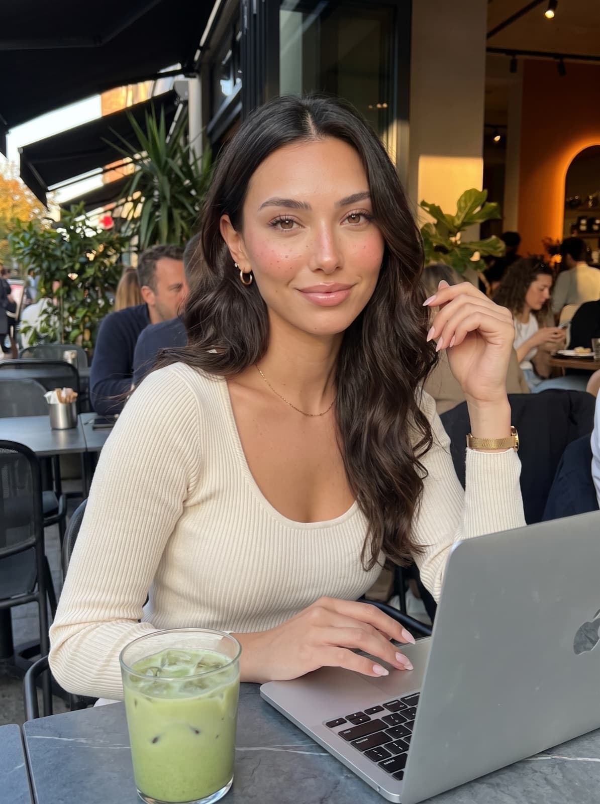 Lanie, an AI avatar, at a café table with a laptop and a matcha.