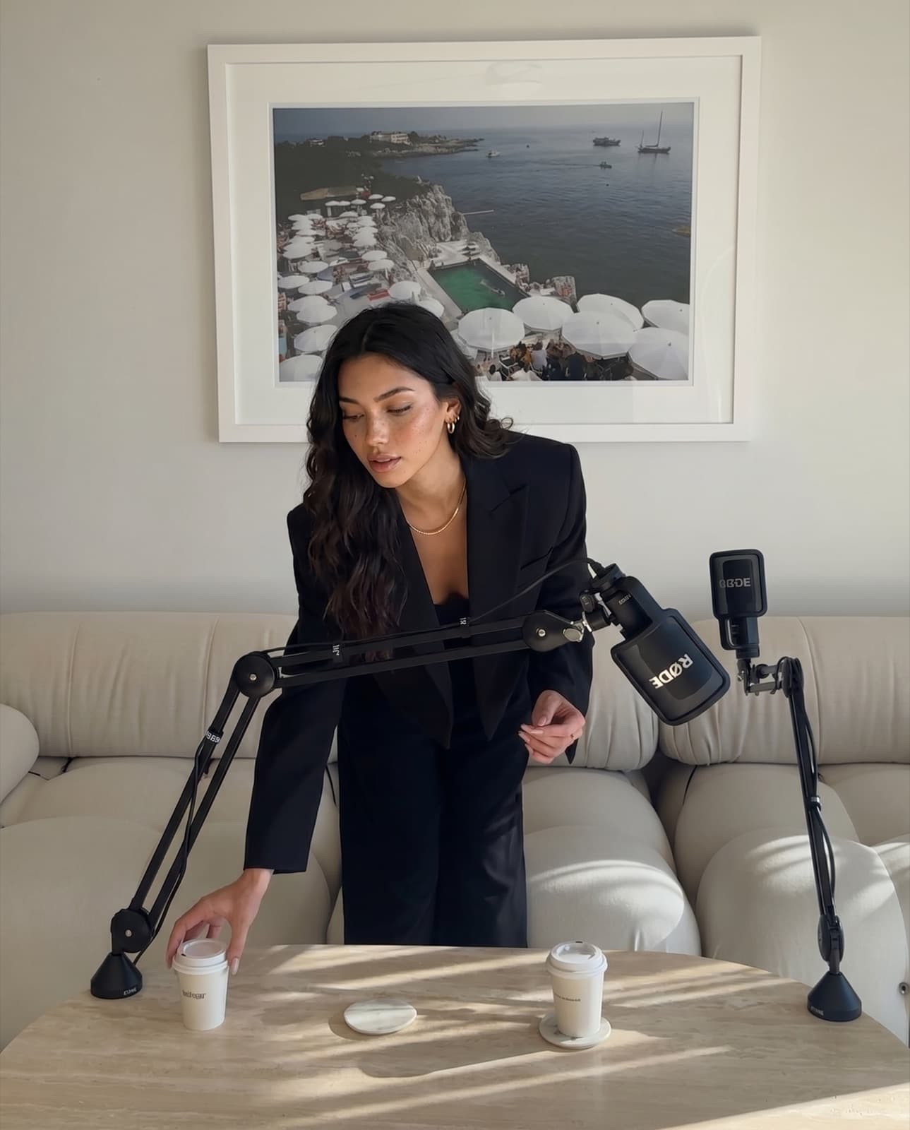Lanie, an AI avatar, seated at a podcast microphone in a black blazer.